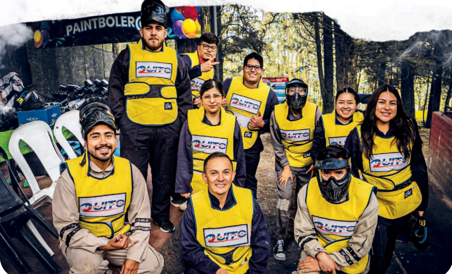 Equipo de trabajo con chalecos amarillos de QuitoPaintball posa tras su taller de team building
